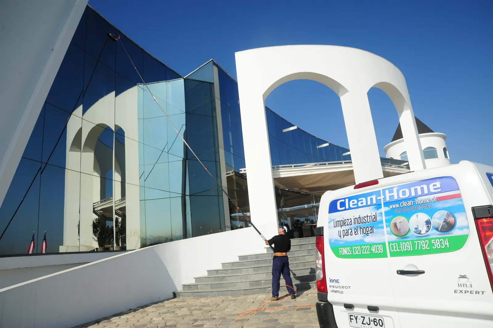Camioneta de Clean-Home frente a un edificio de cristal