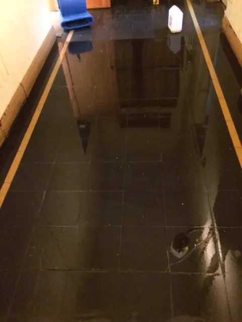 Piso oscuro vitrificado en pasillo
